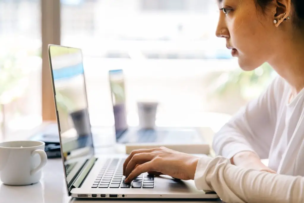 A girl sitting at her laptop and browsing Reddit