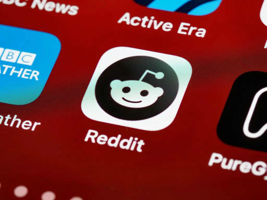 A close up of a phone screen and the Reddit app icon