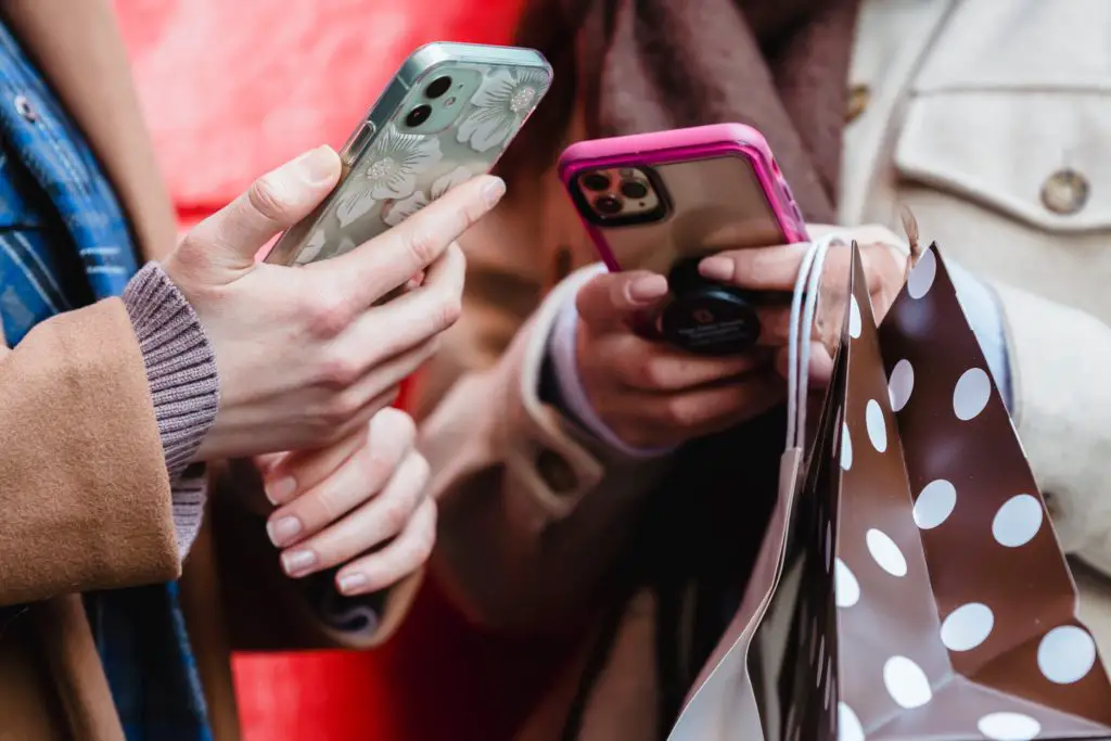 Two women off-screen browsing Reddit on their phones