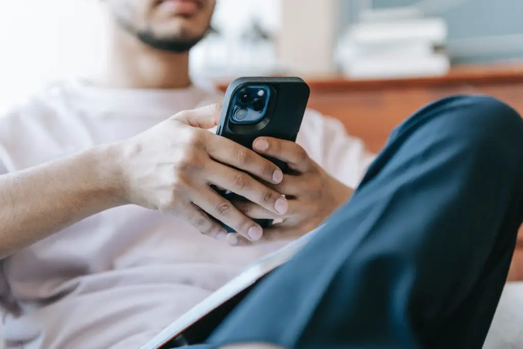 A man sitting in a chair and holding his phone