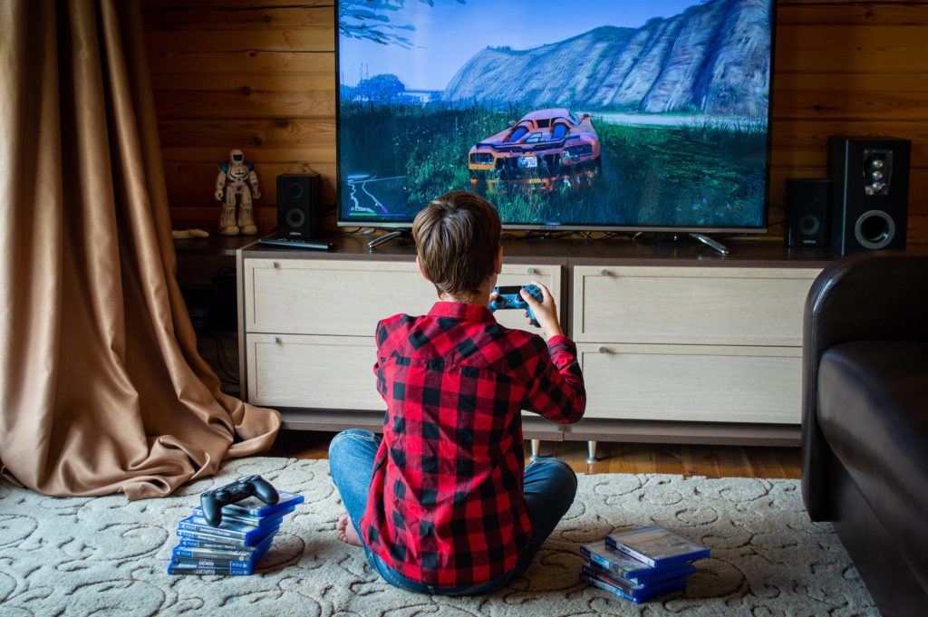 Boy playing a game on PlayStation4 console 
