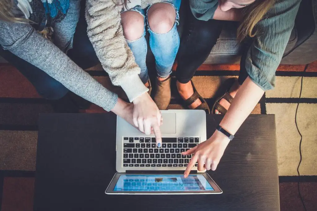 A few people looking and pointing at a laptop